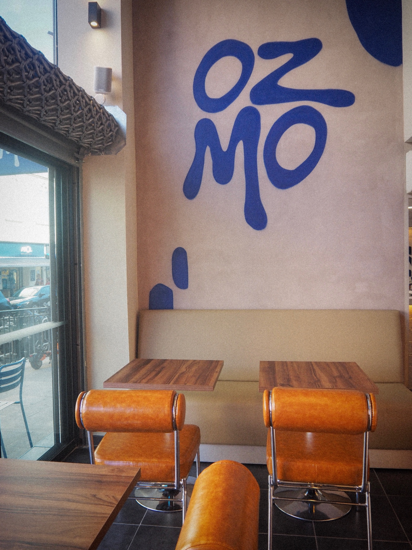 Le mur signature OZMO en bleu marine et les banquettes cognac